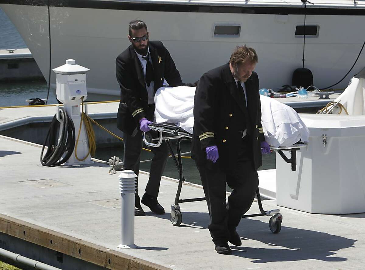 Medical examiners remove the body of a man from a Marina District dock who died after an Artemis team America's Cup racing boat apparently capsized, sending the entire crew into the bay in San Francisco, Calif. on Thursday, May 9, 2013.