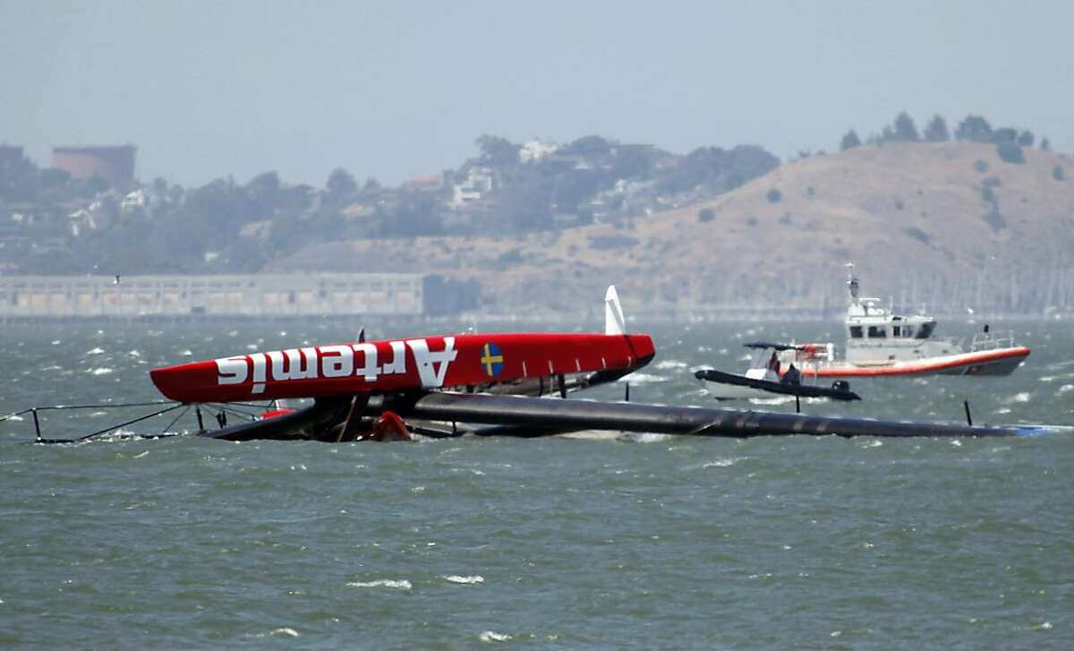 The capsized Artemis catamaran, a 72-foot America's Cup entry from Sweden, is towed past Treasure Island in San Francisco Bay on Thursday, May 9, 2013. A sailor died Thursday, May 9, 2013 after the catamaran of a Swedish team training for the upcoming America's Cup races capsized on San Francisco Bay, emergency officials said. The male sailor was trapped under the Artemis Racing boat for about 10 minutes, according to a statement on the America's Cup website, which said emergency crews tried to revive him. AFP PHOTO / Bay Area News Group / Karl MONDON == RESTRICTED TO EDITORIAL USE / MANDATORY CREDIT: "AFP PHOTO / Bay Area News Group / Karl MONDON" / NO INTERNET / NO ARCHIVES / NO SALES / NO MARKETING / NO ADVERTISING CAMPAIGNS / DISTRIBUTED AS A SERVICE TO CLIENTS ==Karl Mondon/AFP/Getty Images