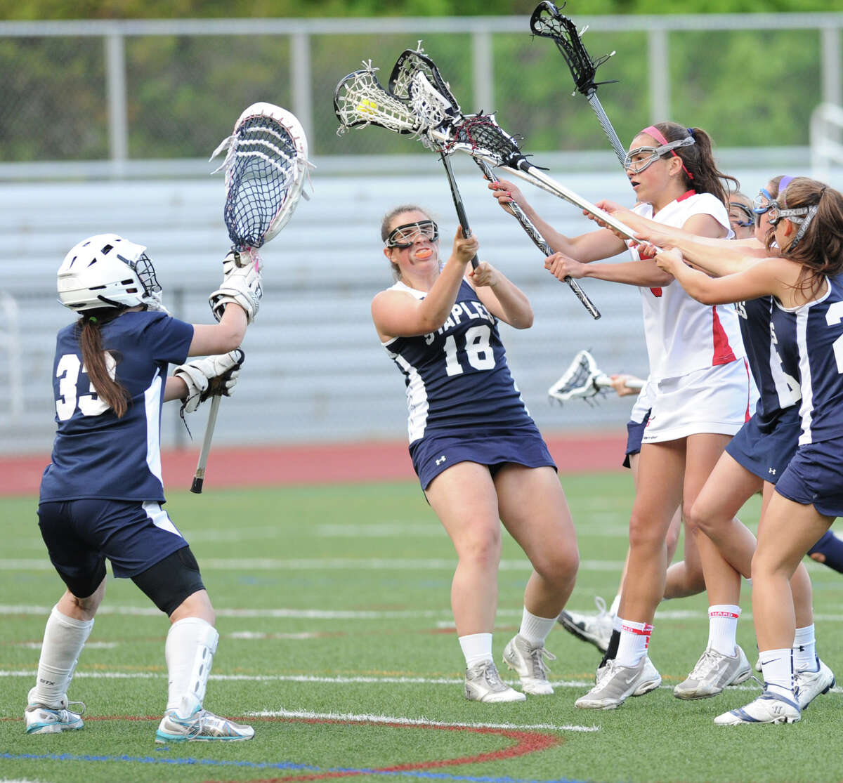 At right, Emma Christie of Greenwich shoots and scores past Staples goalie Emma Boland during the girls high school lacrosse match between Greenwich High School and Staples High School at Greenwich, Thursday, May 9, 2013. At center is Deanna Schreiber (# 18) of Staples.