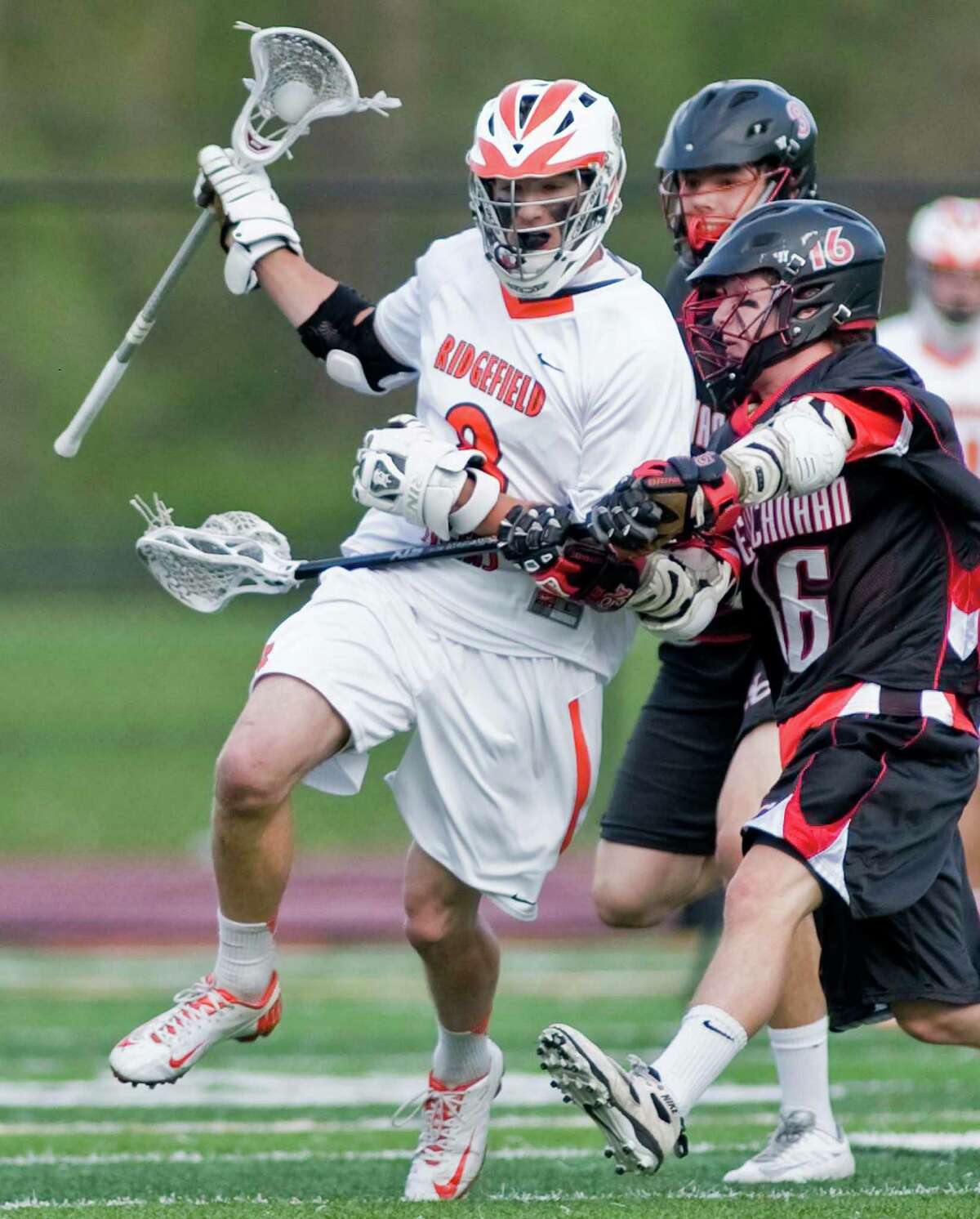 Ridgefield High School's Tim Cozens tries to get by New Canaan High School's Henry Stanton during a game against , played at Ridgefield. Thursday, May 9, 2013