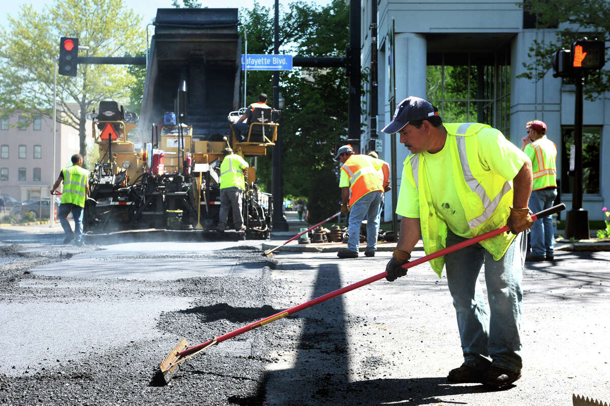 Leo Ayala, an employee of Empire Paving, works to level hot asphalt on John Street, in Bridgeport, Conn., May 10th, 2013. Traffic throughout downtown has been detoured in various directions for a couple of weeks during the major paving project.