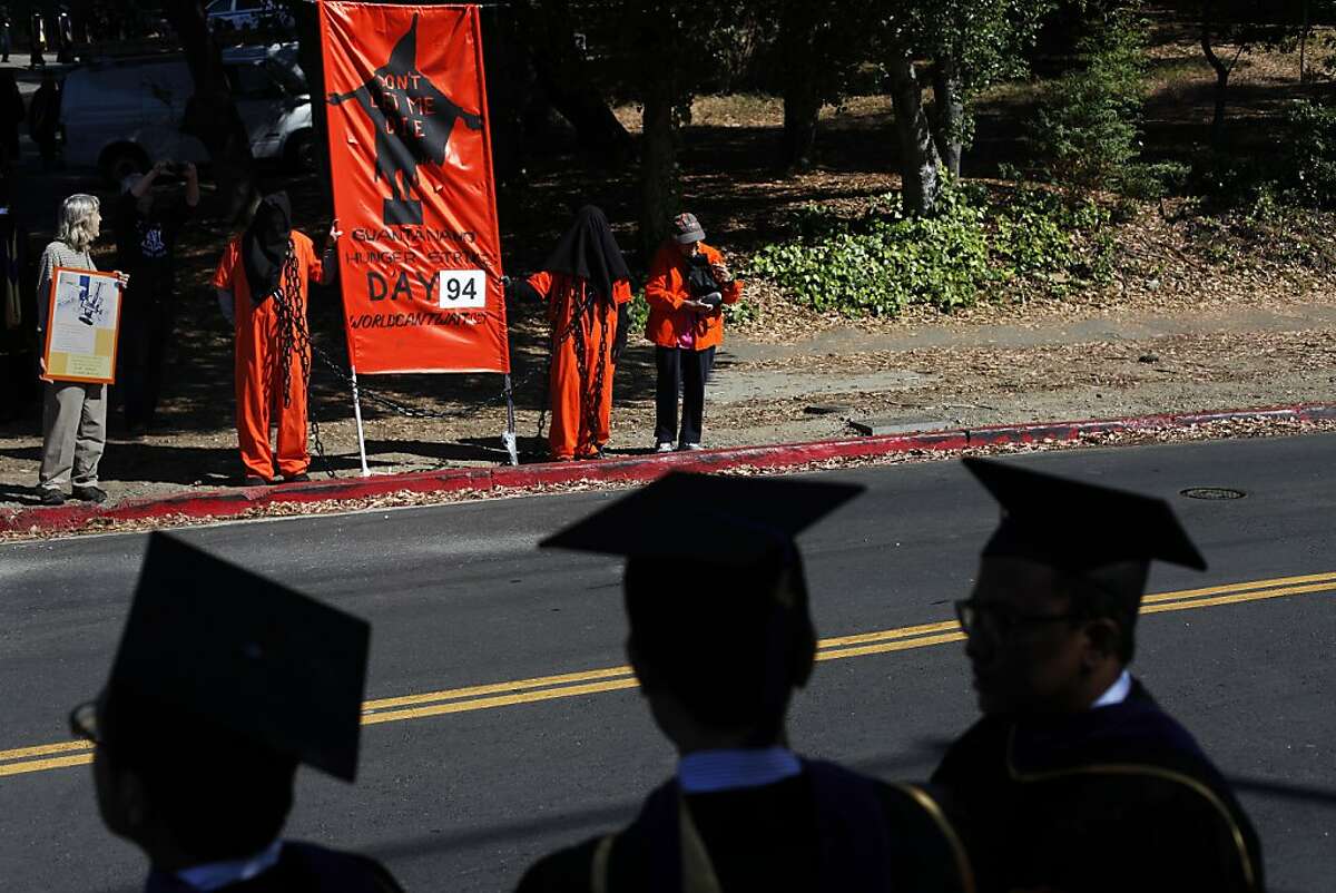 Berkeley Law School graduates look on as protesters greet them before entering the Greek Theater in Berkeley, Calif. on Saturday, May 11 2013. U.S. Attorney General Eric Holder came to Berkeley to speak at the Law School's graduation ceremony and was met with protest.