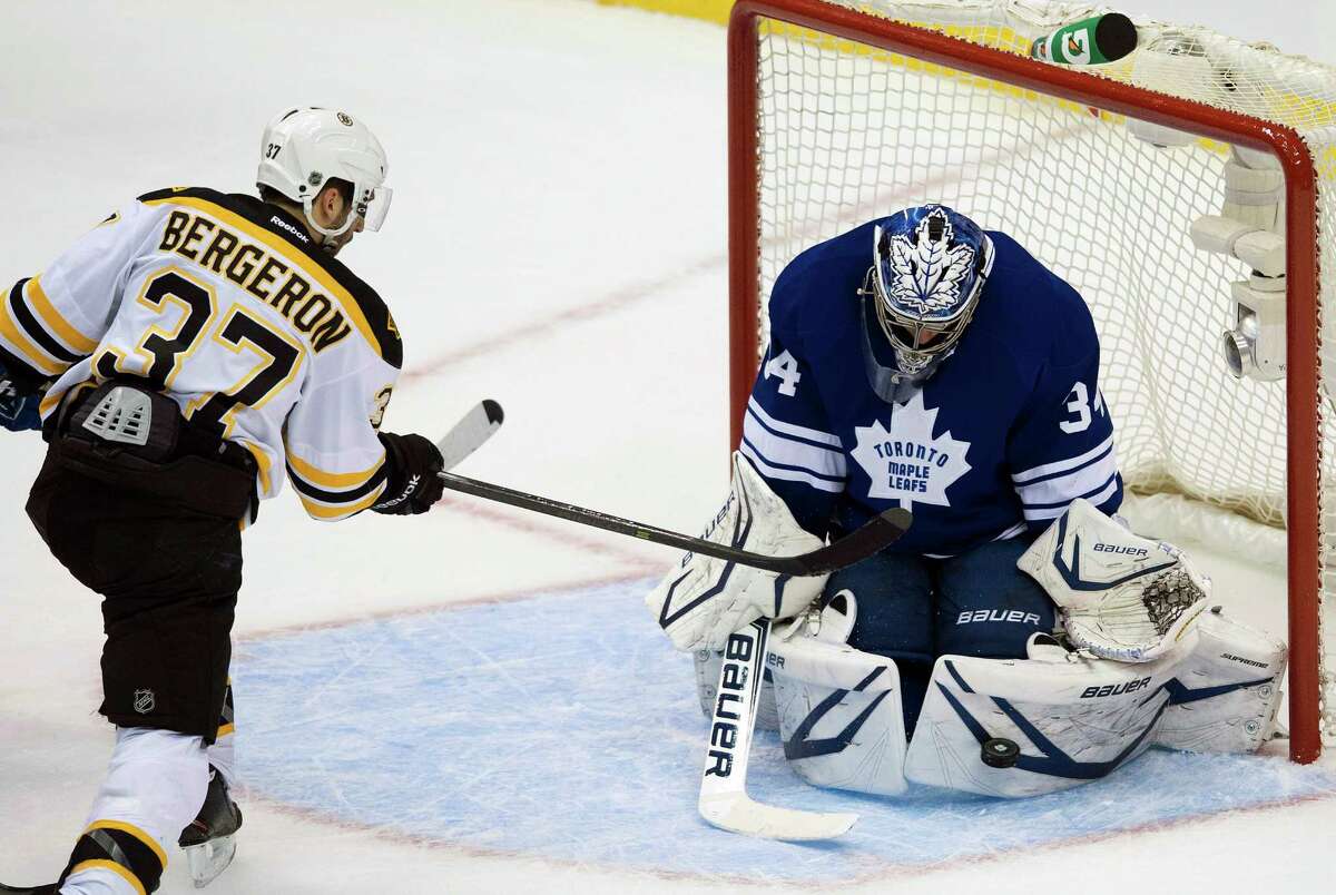 Maple Leafs goalie James Reimer, who didn't let anything get past him until the final minute of the game, makes a save on the Bruins' Patrice Bergeron.