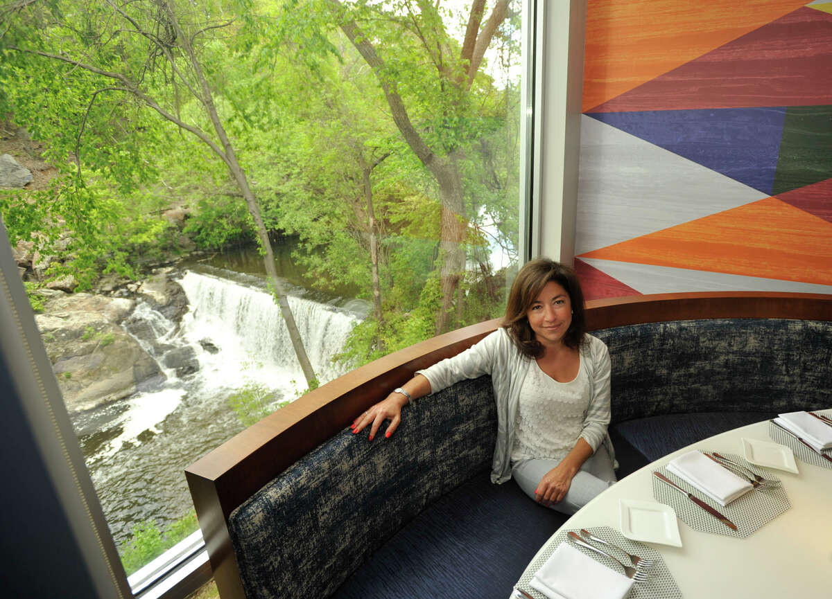 Mia Schipani, the spokesperson for RMS Construction and Hoel Zero Degrees in Norwalk, sits in front of a window overlooking the Norwalk River in Mediterraneo, the restaurant located within Hotel Zero Degrees, in Norwalk on Monday, May 13, 2013.