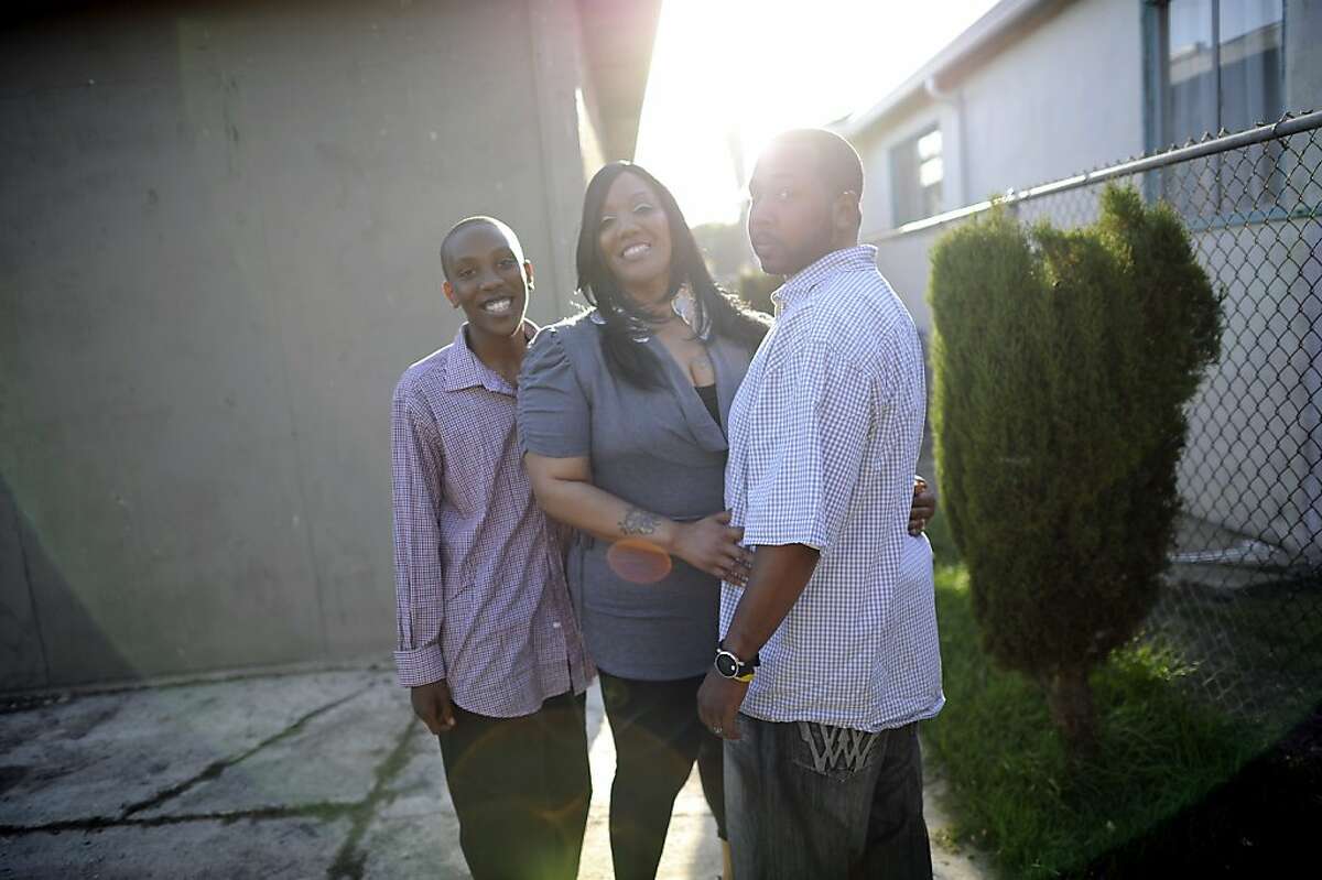 Wakeelah and Andre Davis pose for a portrait with their son Dre'onn, 13, in the backyard of their home in Richmond, CA Tuesday May 7th, 2013. The Davis family recently bought their home with the help of the nonprofit Self Help, which buys and fixes up foreclosures for sale to low-income owners.