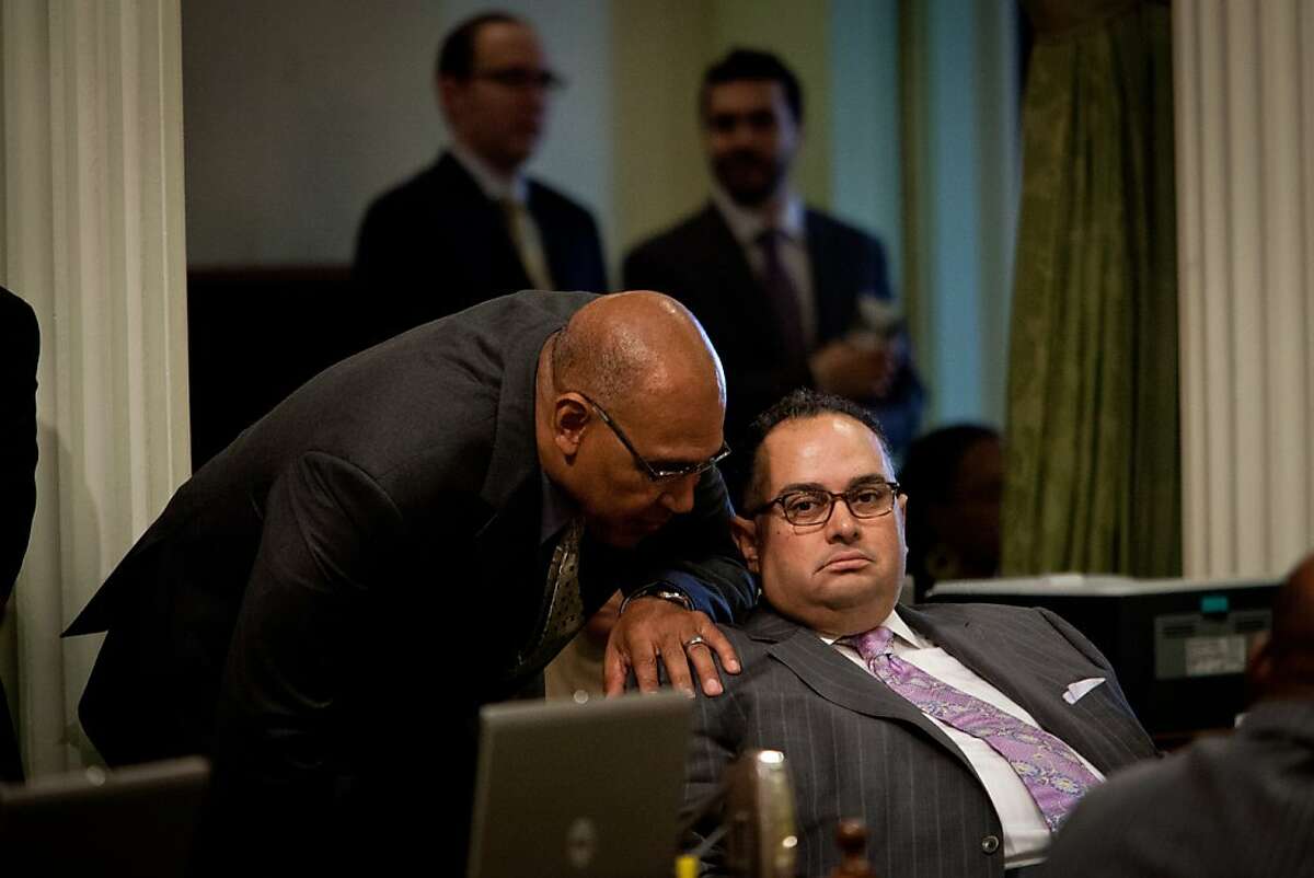 California State Assemblymember Chris Holden, left, speaks with Assembly Speaker John Perez, right, during a legislative session in Assembly chambers at the State Capitol in Sacramento, California, April 29, 2013.