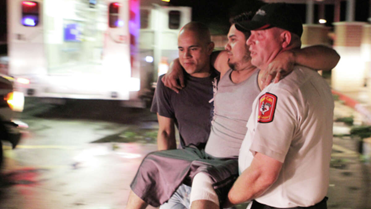 Johnny Ortiz, left, and James South, right, carry Miguel Morales, center, who was injured in a tornado, to an ambulance in Granbury, Texas, on Wednesday May 15, 2013. Officials report the tornado caused "multiple fatalities" as it tore through two neighborhoods of a North Texas town. Hood County sheriff's Lt. Kathy Jiveden reported the multiple fatalities, but she had no estimate of dead or injured.