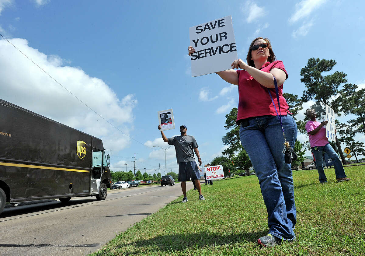 From left, Charles Lee, Traci Syas, and Debora Hunter picket in front of the Dowlen Road Post Office on Thursday. Along with about 15 others, the group of postal employees waived signs towards traffic and got signatures from people dropping off mail. Photo taken Thursday, March 16, 2013 Guiseppe Barranco/The Enterprise