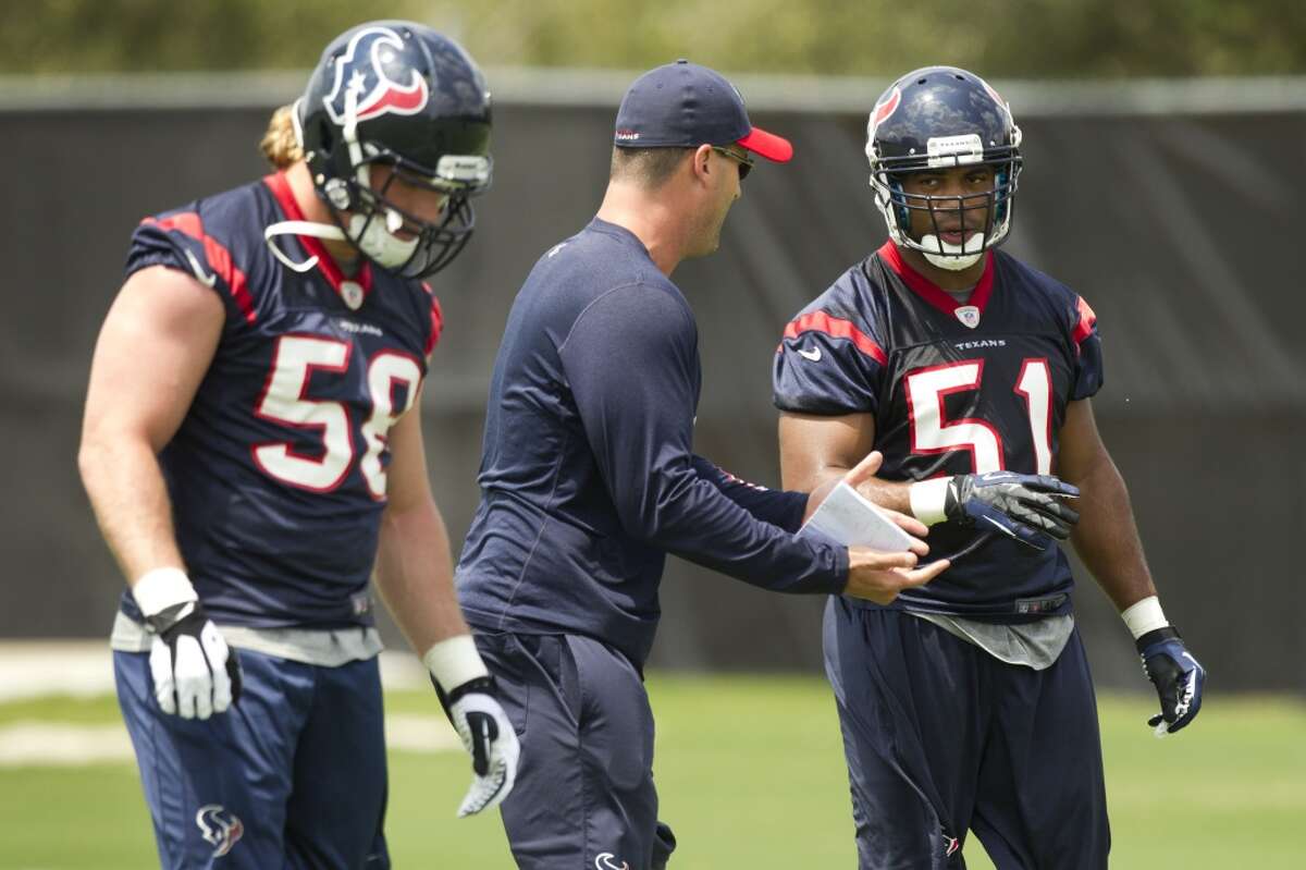 Texans linebackers Brooks Reed (58) and Darryl Sharpton (51) work with assistant linebackers coach Bobby King, center.