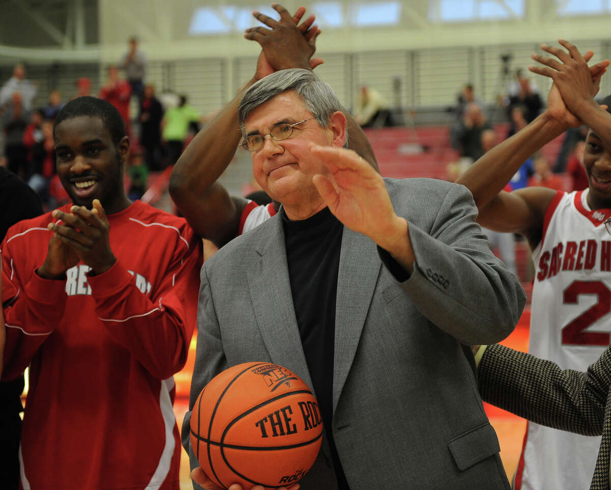 Sacred Heart men's basketball coach Dave Bike accepts the game ball and acknowledges the crowd after his 500th career victory at the Pitt Center at Sacred Heart University in Fairfield on Sunday, January 2, 2011.