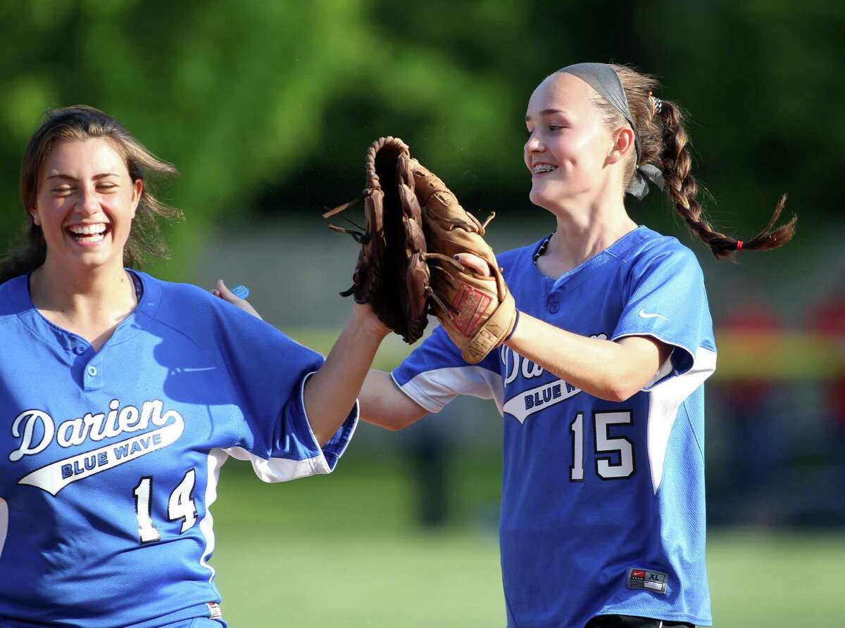 Darien High School softball players Julia Domiziano and Avery Maley exchange high fives following the Blue Wave's FCIAC win over Greenwich in the quarterfinals at Darien High School on Monday, May 20, 2013.