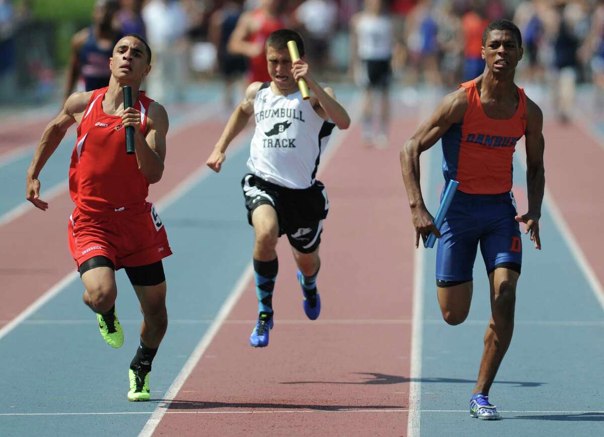 Danbury's Mathew Andrew, right, edges out Greenwich's Austin Longi, left, and Trumbull's Joe Matera, in the final leg of the boys 4x100 meter relay race at the FCIAC Track and Field Championships at Danbury High School in Danbury, Conn. on Tuesday, May 21, 2013. Danbury won the race.