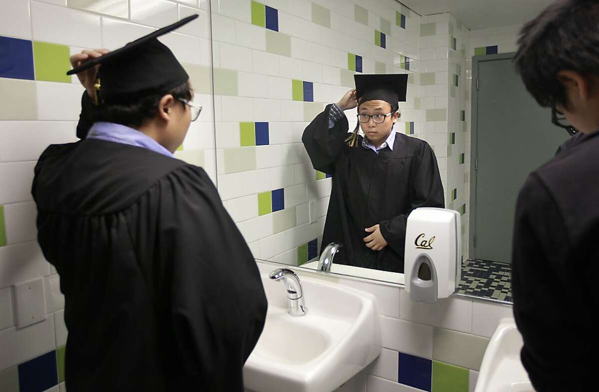 Terrence Park, (left) on Wed. May 22, 2013, in Berkeley, Calif., prepares for his graduation ceremony at UC Berkeley wearing the gown that he got from a new program that encourages graduating students to donate their gowns to needy students who can't afford the $50 price of a new one.