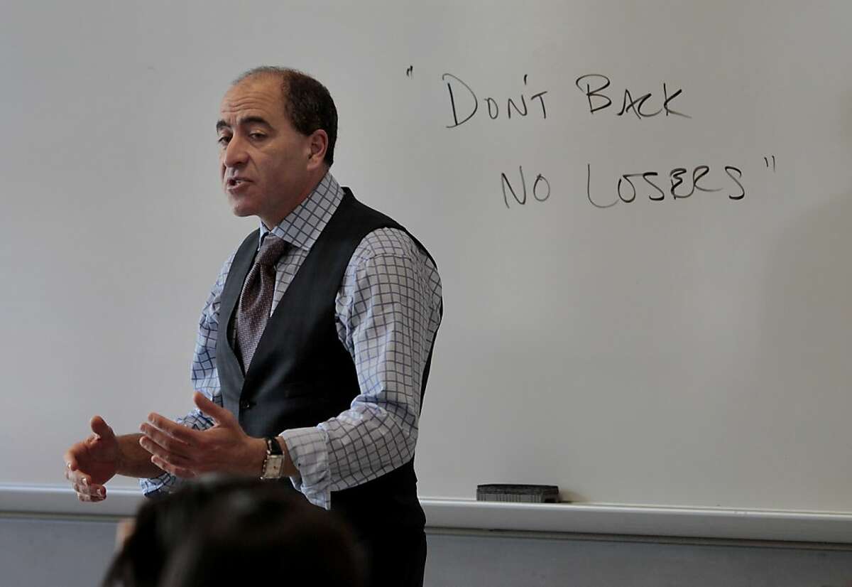 Joe Tuman makes a point during a class next to a notation he put on the white board about political donators wanting to back a winner. Joe Tuman is a professor at San Francisco State University and a political commentator on radio and television who may run for mayor of Oakland, Calif. in the next election.