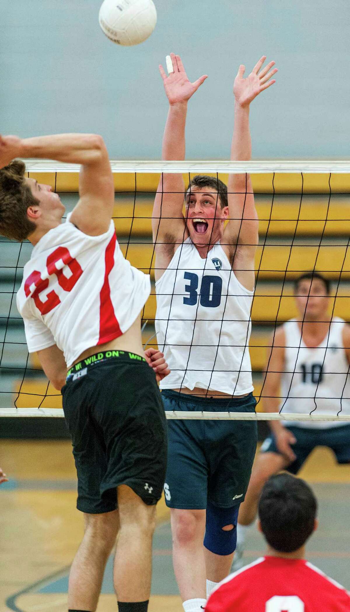 Staples high school's Todd Goldstein goes up to block a spike by Greenwich high school's Zak Steiner during an FCIAC boys volleyball semifinal match played at Fairfield Ludlowe high school, Fairfield, CT on Wednesday May 22nd, 2013.