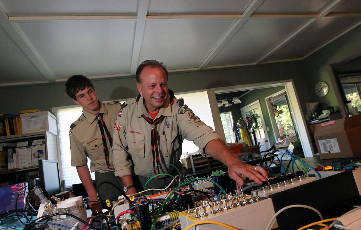 Matthias Baker 15, looks over his fathers shoulder, Wendell Baker troop 234 leader as dad explains the how his engineering prototype boards work Thursday, May 22, 2013 in Moraga Calif,