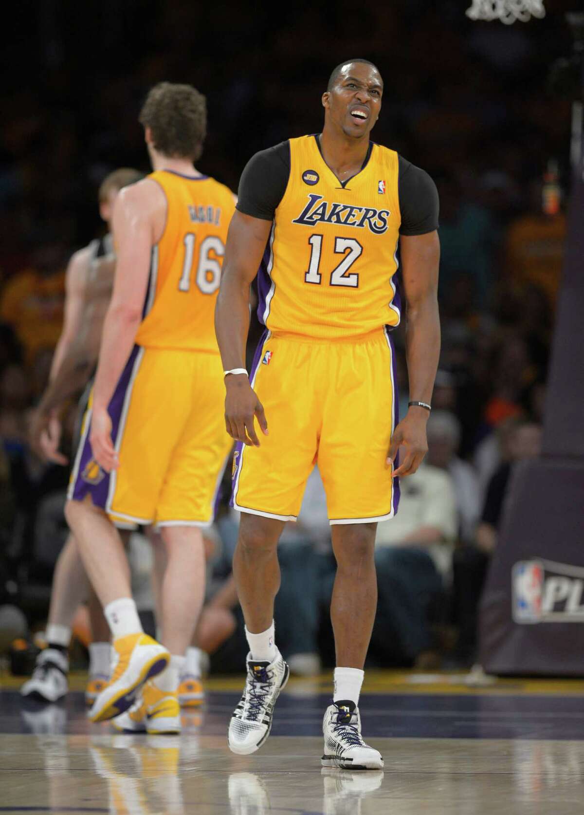 Los Angeles Lakers center Dwight Howard, right, appears fatigued as forward Pau Gasol, of Spain, stand in the background during the first half in Game 3 of a first-round NBA basketball playoff series, Friday, April 26, 2013, in Los Angeles. (AP Photo/Mark J. Terrill)