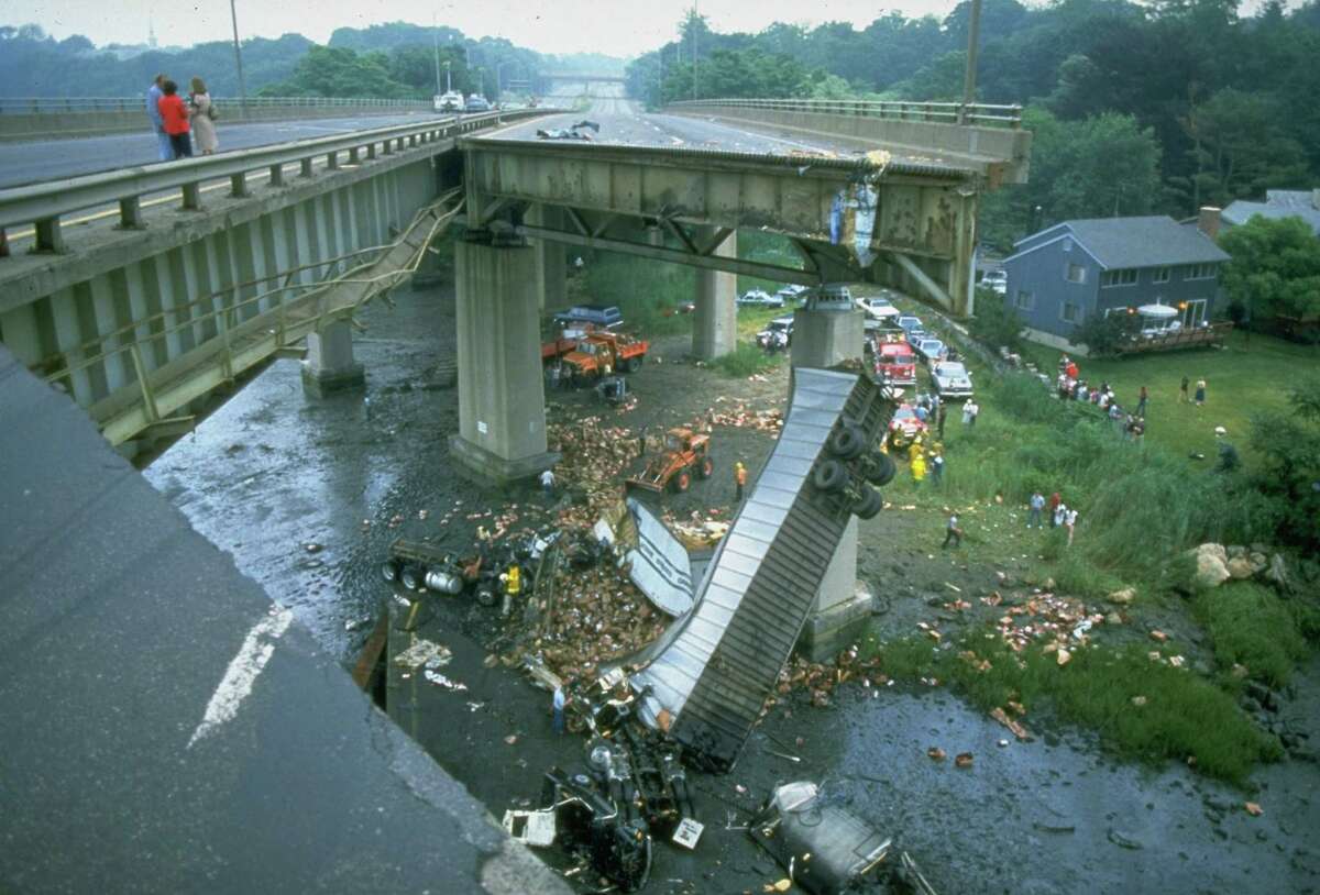 Twisted tractor trailer truck lies 70 feet below collapsed section of Mianus River bridge on I-95. (Photo by Hank Morgan//Time Life Pictures/Getty Images)