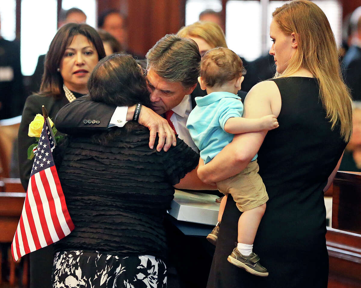 Gov. Rick Perry hugs Rufina Aranda, mother of the late Sgt. Lorenzo Aranda Jr., with wife Heather Scott and son Lorenzo, on Saturday as the Legislature honored fallen Texas military personnel.