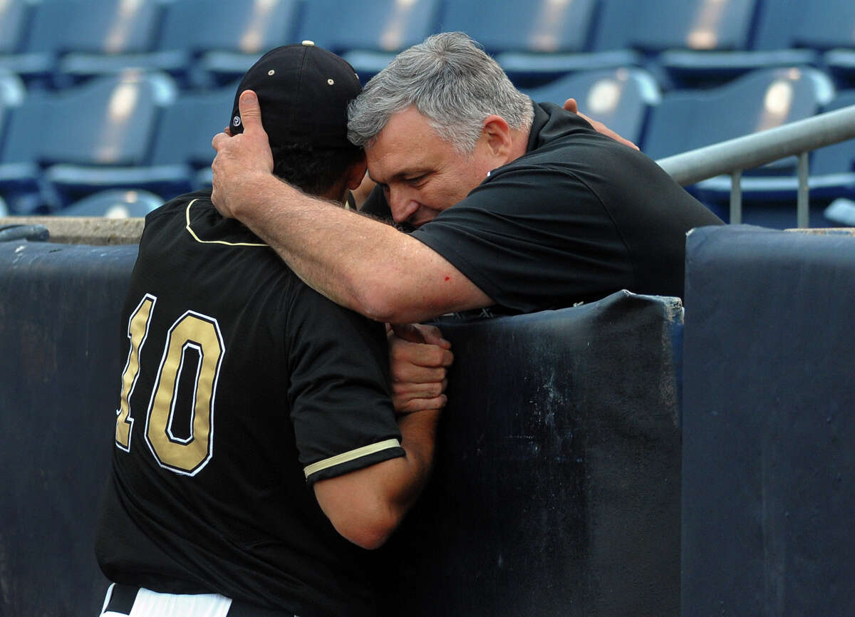 Trumbull High's Athletic Director, Mike Herbst, hugs Casey Mack after the team beat Greenwich, during FCIAC Baseball Championship semi-final action at the Ballpark at Harbor Yard in Bridgeport, Conn. on Wednesday May 22, 2013.
