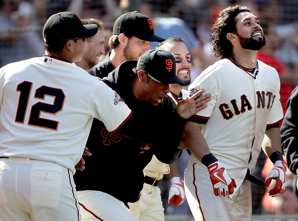 The Giants' Marco Scutaro, (left) Brandon Crawford, (35) Angel Pagan, (16),  and Andres Torres, (behind) celebrate Pagan's winning run with an inside  the park homer in the tenth inning as the San