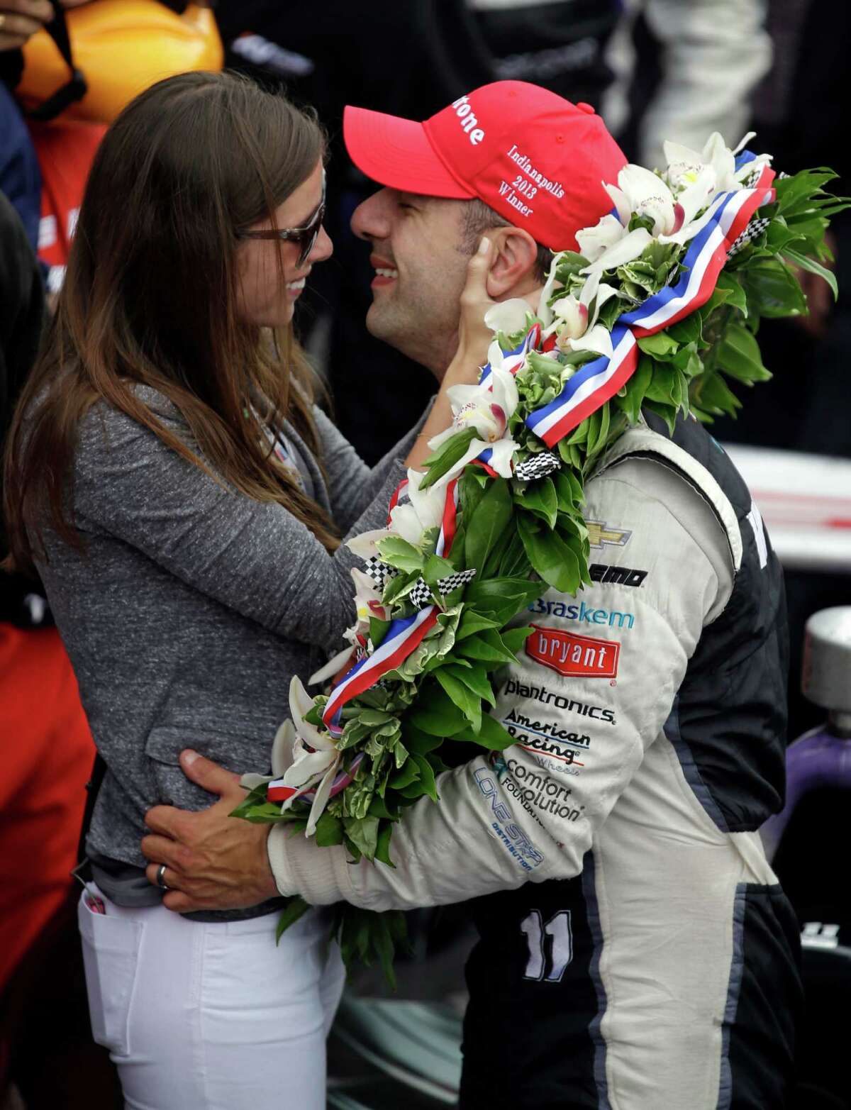 Tony Kanaan, of Brazil, kisses his wife Lauren Bohlander Kanaan after winni...