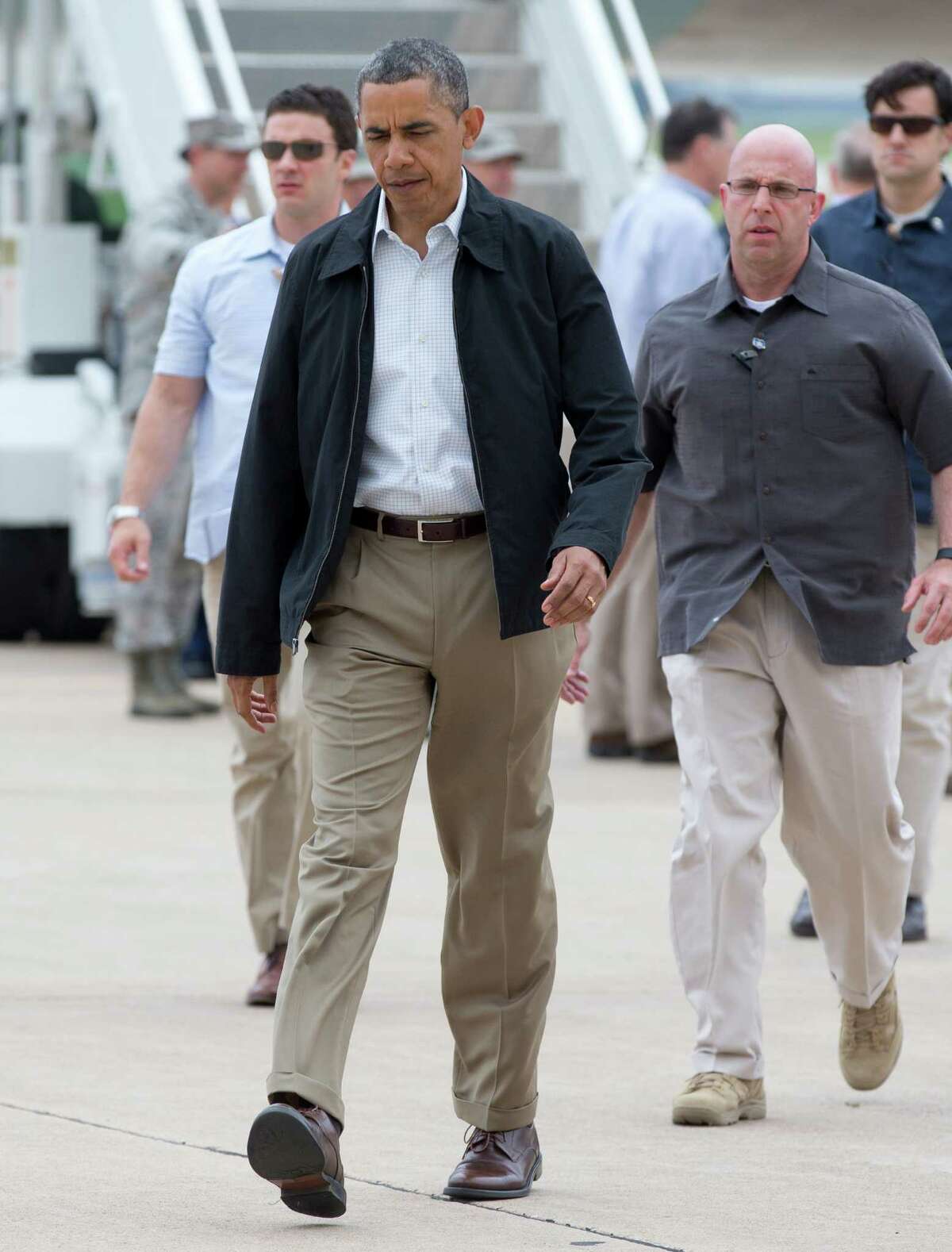 President Barack Obama walks across the tarmac to greet people as he arrives on Air Force One, Sunday, May 26, 2013, at Tinker Air Force Base in Midwest City, Okla., en route to the Moore, Okla., to see the response to the severe tornadoes and weather that devastated the area. He will also visit with the families affected, and with first responders. (AP Photo/Carolyn Kaster)