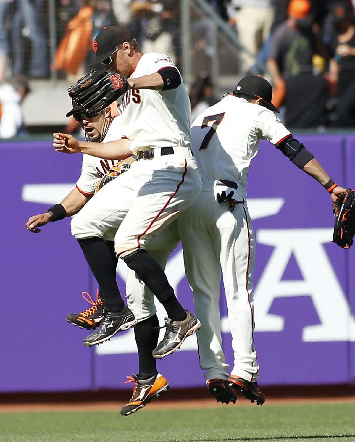 San Francisco Giants' Andres Torres, left, Hunter Pence, center, and Gregor Blanco celebrate after defeating the Colorado Rockies 7-3 in a baseball game on Sunday, May 26, 2013, in San Francisco. (AP Photo/George Nikitin)