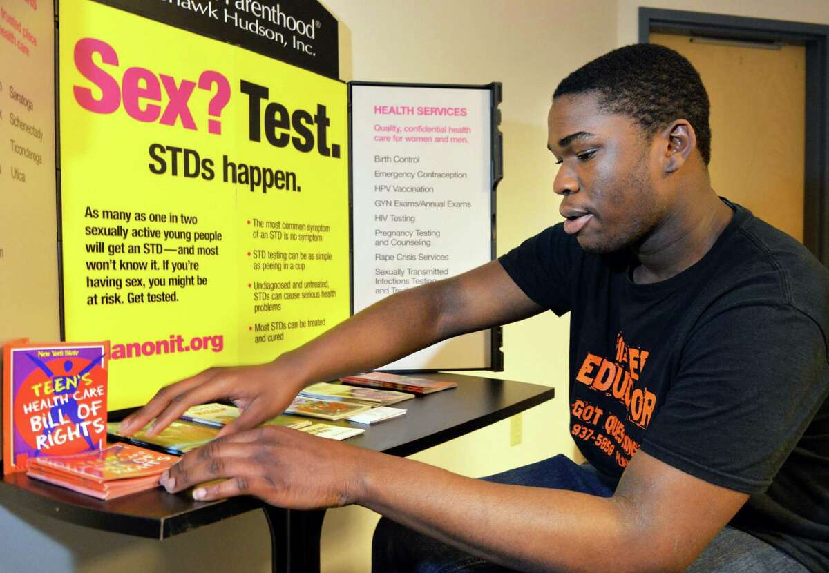 Schenectady High senior Joshua Sayles, a Planned Parenthood peer educator prepares a table display at Planned Parenthood Mohawk Hudson in Schenectady, NY, Friday May 24, 2013. (John Carl D'Annibale / Times Union)