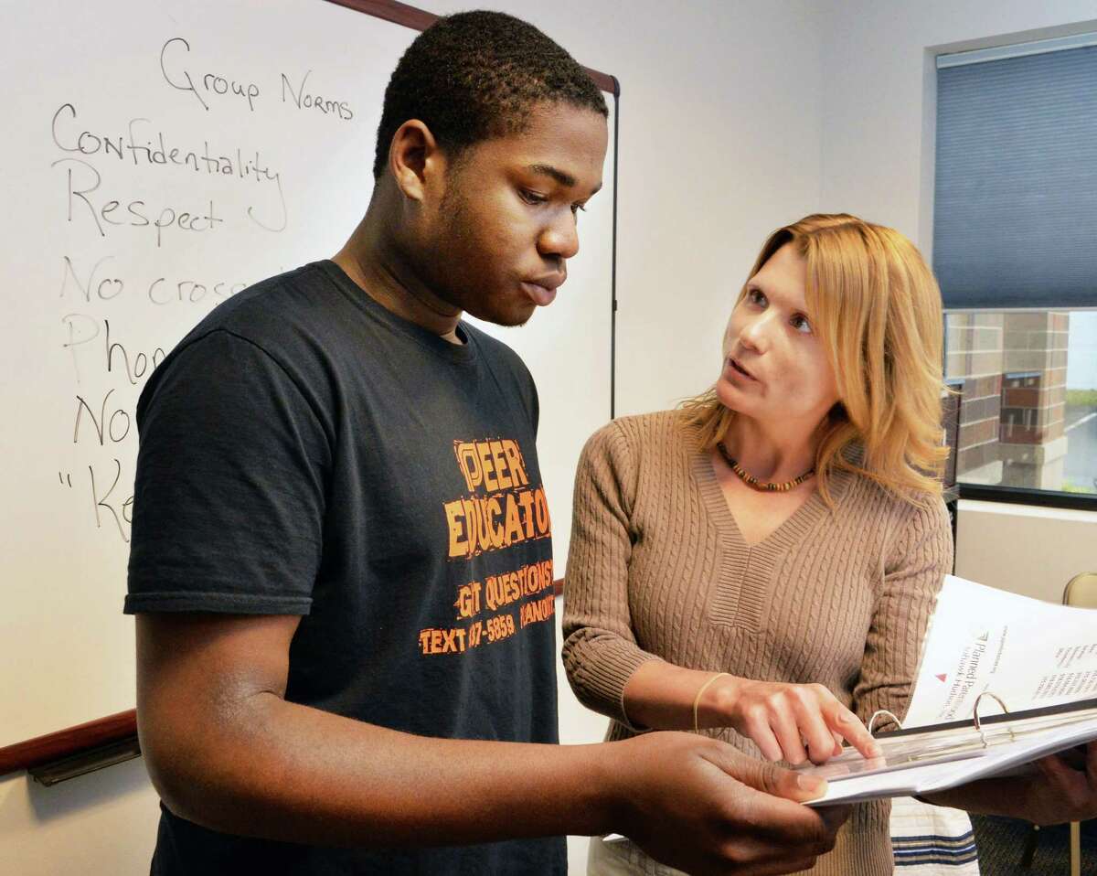Schenectady High senior and Planned Parenthood peer educator Joshua Sayles, left, and education team manager Eileen Lawson review plans at Planned Parenthood Mohawk Hudson in Schenectady, NY, Friday May 24, 2013. (John Carl D'Annibale / Times Union)