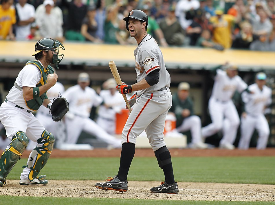 The Giants' Marco Scutaro, (left) Brandon Crawford, (35) Angel Pagan, (16),  and Andres Torres, (behind) celebrate Pagan's winning run with an inside  the park homer in the tenth inning as the San