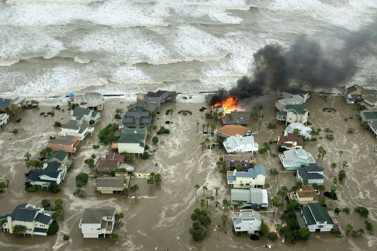 A house is totally engulfed in flames as floodwaters and crashing waves inundated beach homes on Galveston Island as Hurricane Ike approached the Texas Gulf Coast, Friday, Sept. 12, 2008. ( Smiley N. Pool / Chronicle )