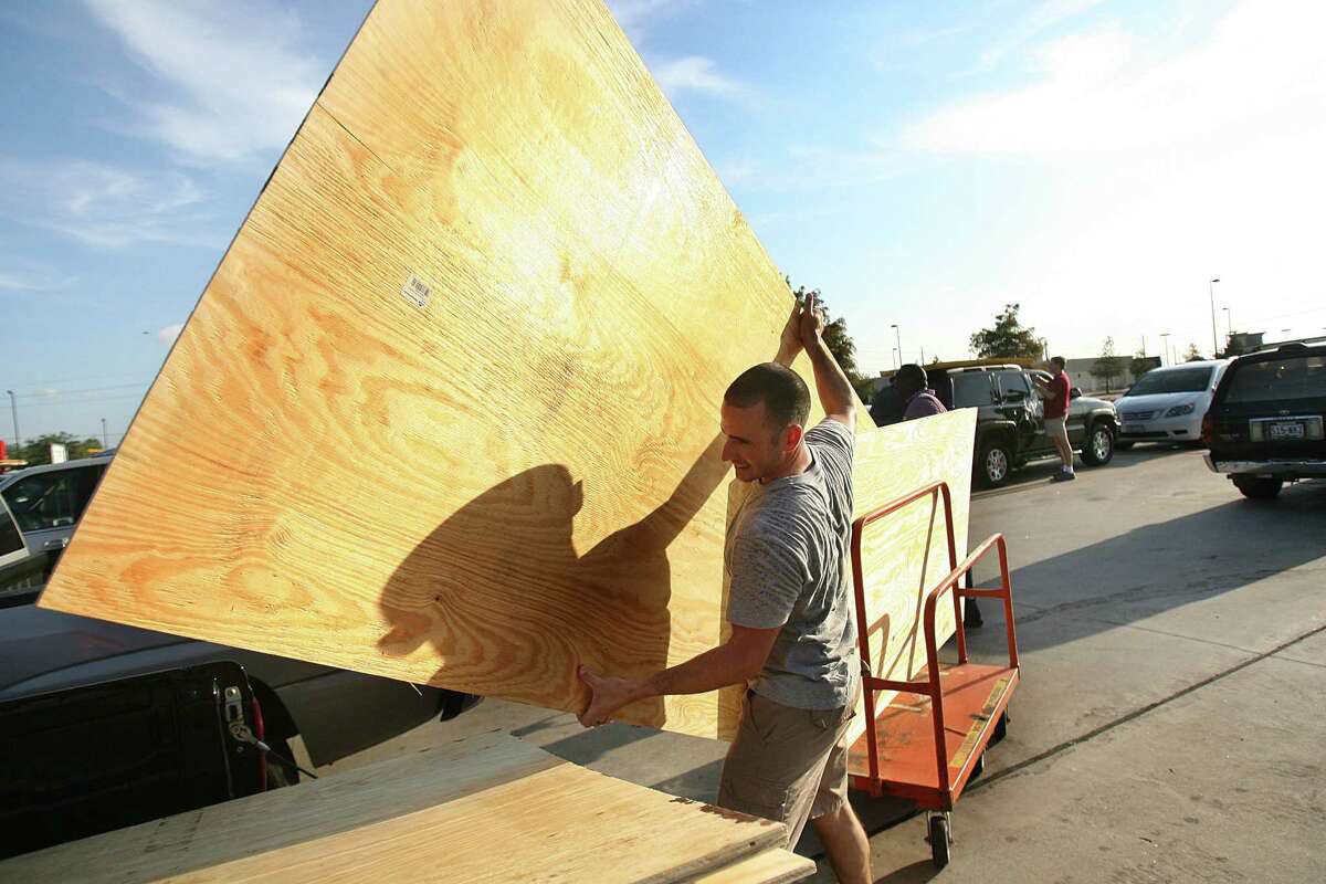 Eric Trevino, of Pearland, loads plywood into his truck at Home Depot in preparation for Hurricane Ike in 2008.