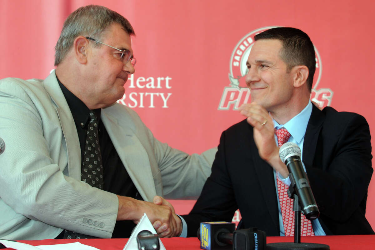 Former Sacred Heart University men's basketball coach Dave Bike, left, shakes hands with new coach, Anthony Latina, during a press confernece in the McMahon Center on campus in Fairfield, Conn., May 30th, 2013.