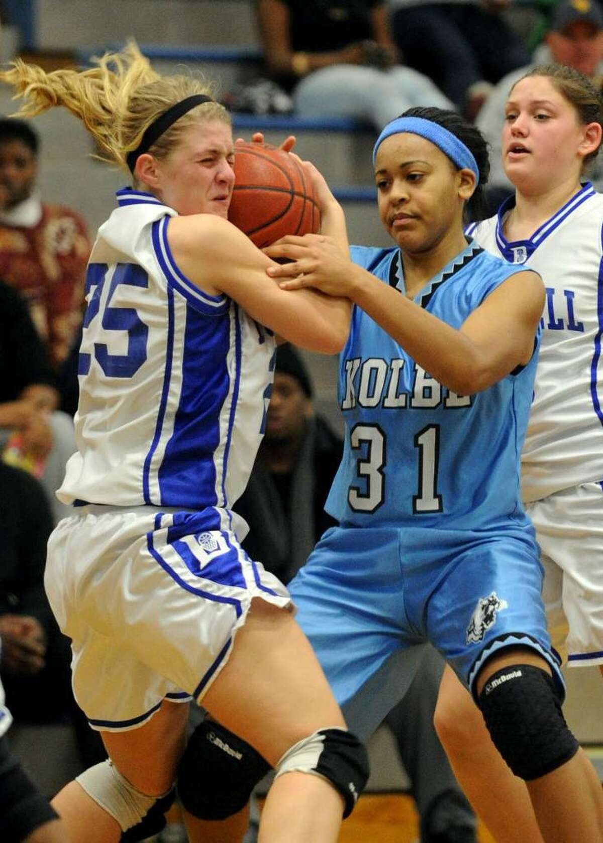 Bunnell's #25 Erynn Miller, left, struggles for control of a loose ball with Kolbe's #31 Cherelle Moore, during girls basketball action in Stratford, Conn. on Tuesday Jan. 12, 2010.