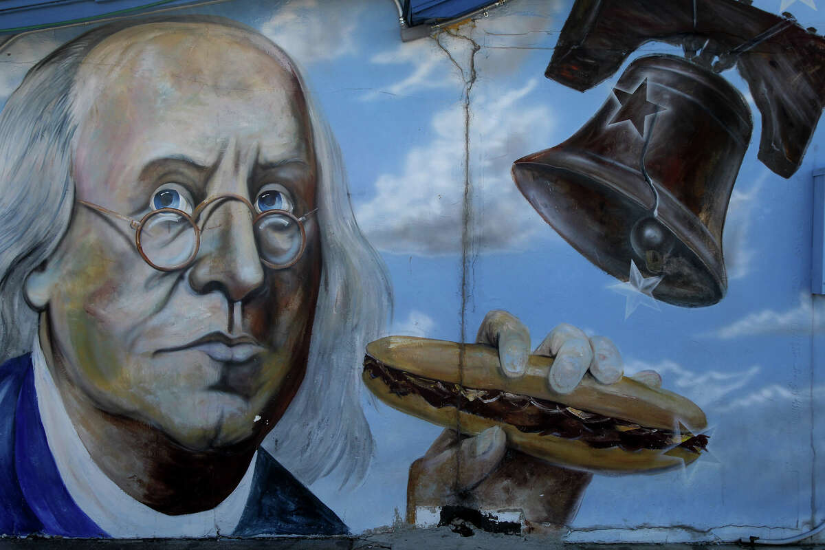 A mural on the side of Youz Guyz restaurant on Pat Booker road shows Benjamin Franklin with a Philly cheese steak sandwich.