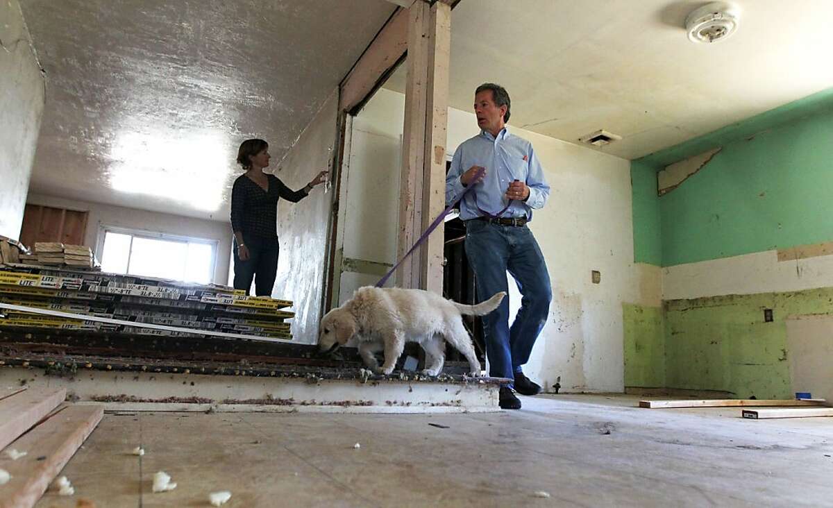 David Waal, principal of Presidio Realty Advisors, and his wife Laura Waal inspect a home he is renovating for re-sale with the family dog Maile Thursday, May 22, 2013 in Martinez Calif.