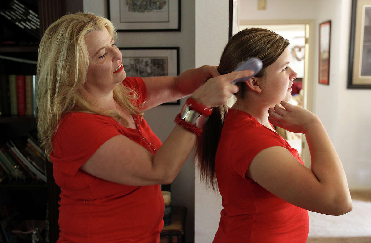 Kelly Lozano (left) helps her 14-year-old daughter, Samantha, as they prepare to attend a Taylor Swift concert.