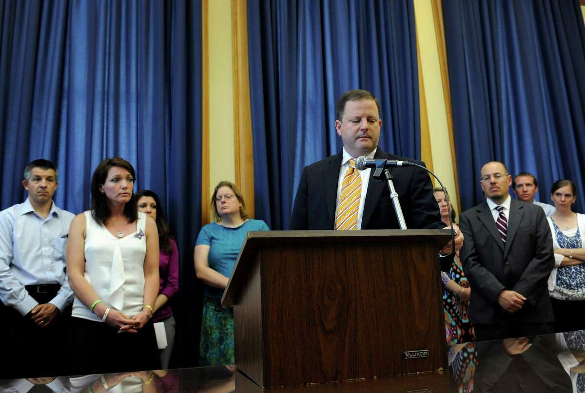 State Sen. Minority Leader John McKinney, R-Fairfield, and representing Newtown, answers questions from the media as families of victims from the Sandy Hook School shooting stand behind him during a news conference at the Capitol in Hartford, Conn., Friday, May 31, 2013. Family members of the school shooting victims are making a last-minute appearance at the state Capitol to urge Connecticut legislators to pass a bill that would block the public release of crime scene photos and other records from the massacre.