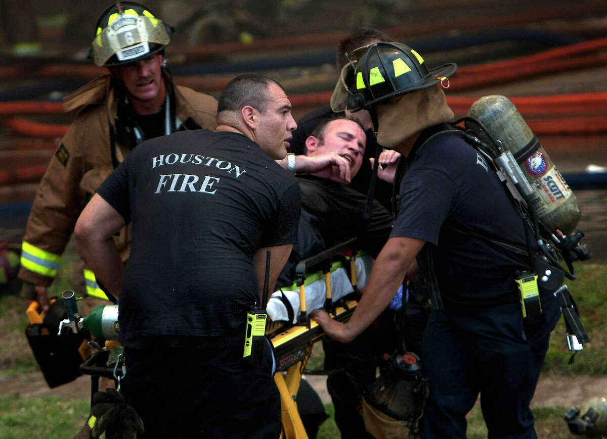 A firefighter is wheeled to an ambulance Friday after being pulled from the scene at the Southwest Inn.