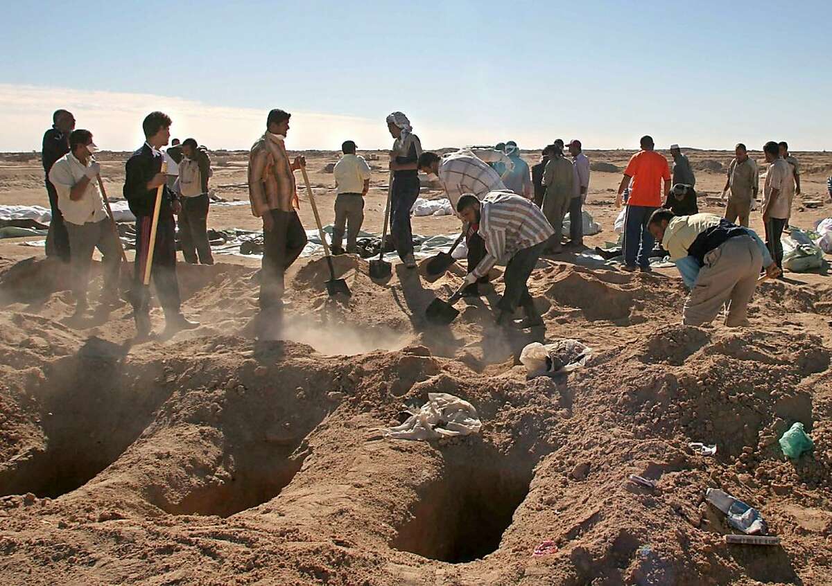 In this Friday, Nov. 10, 2006 file photo, Iraqi volunteers bury bodies in the Shiite holy city of Najaf, 160 kilometers (100 miles) south of Baghdad, Iraq as 176 bodies of victims of recent sectarian violence were brought from Baghdad to Najaf for the funeral. More than a year after the U.S. military left Iraq, the country is reeling from its most sustained violence since 2008. Over the last two months more than 1,200 people have been killed, raising fears the country is sliding back into chaos. (AP Photo/Alaa al-Marjani, File)