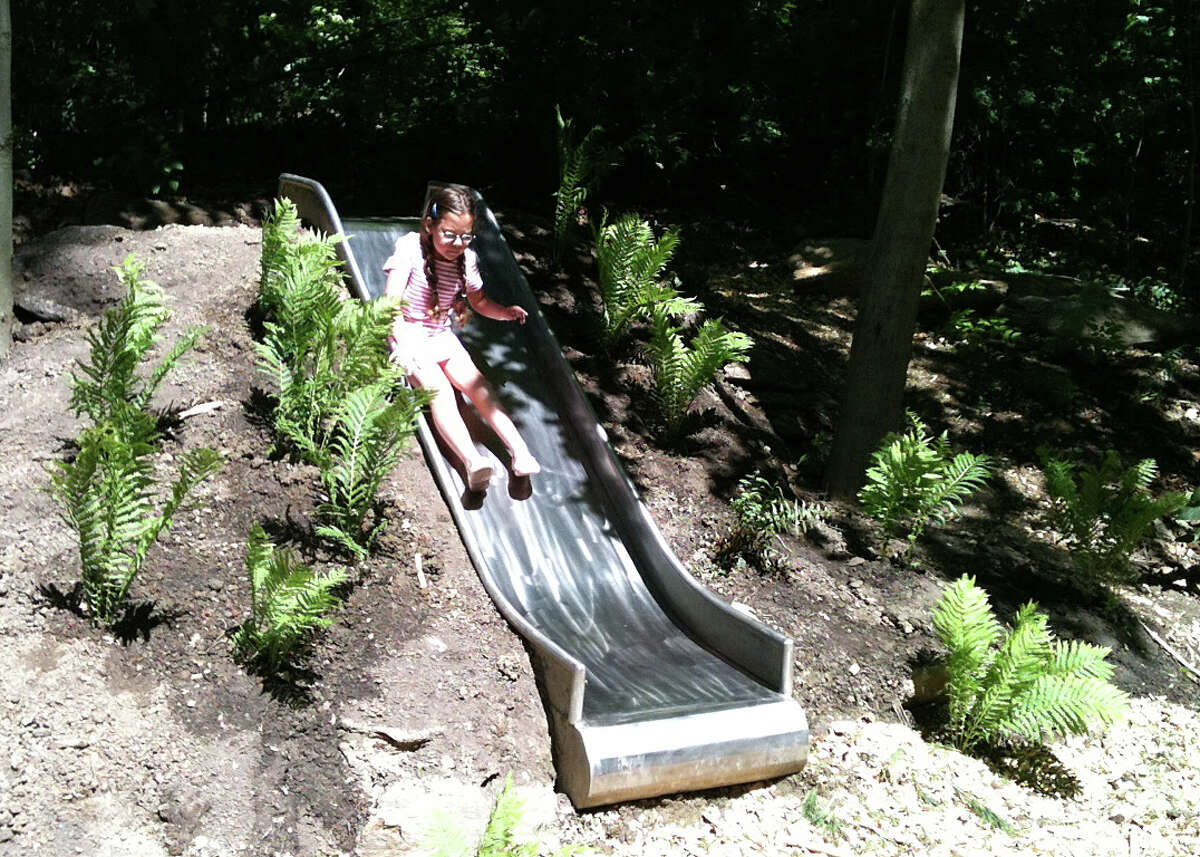 A youngster enjoys the metal slide installed into the landscape at the new Southport Park. FAIRFIELD CITIZEN, CT 6/1/13