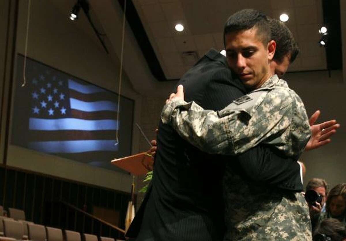 Rick Artus, pastor of Christian Life Church, left, embraces Pfc. Cameron Parrott after a prayer service at First Baptist Church in Killeen.