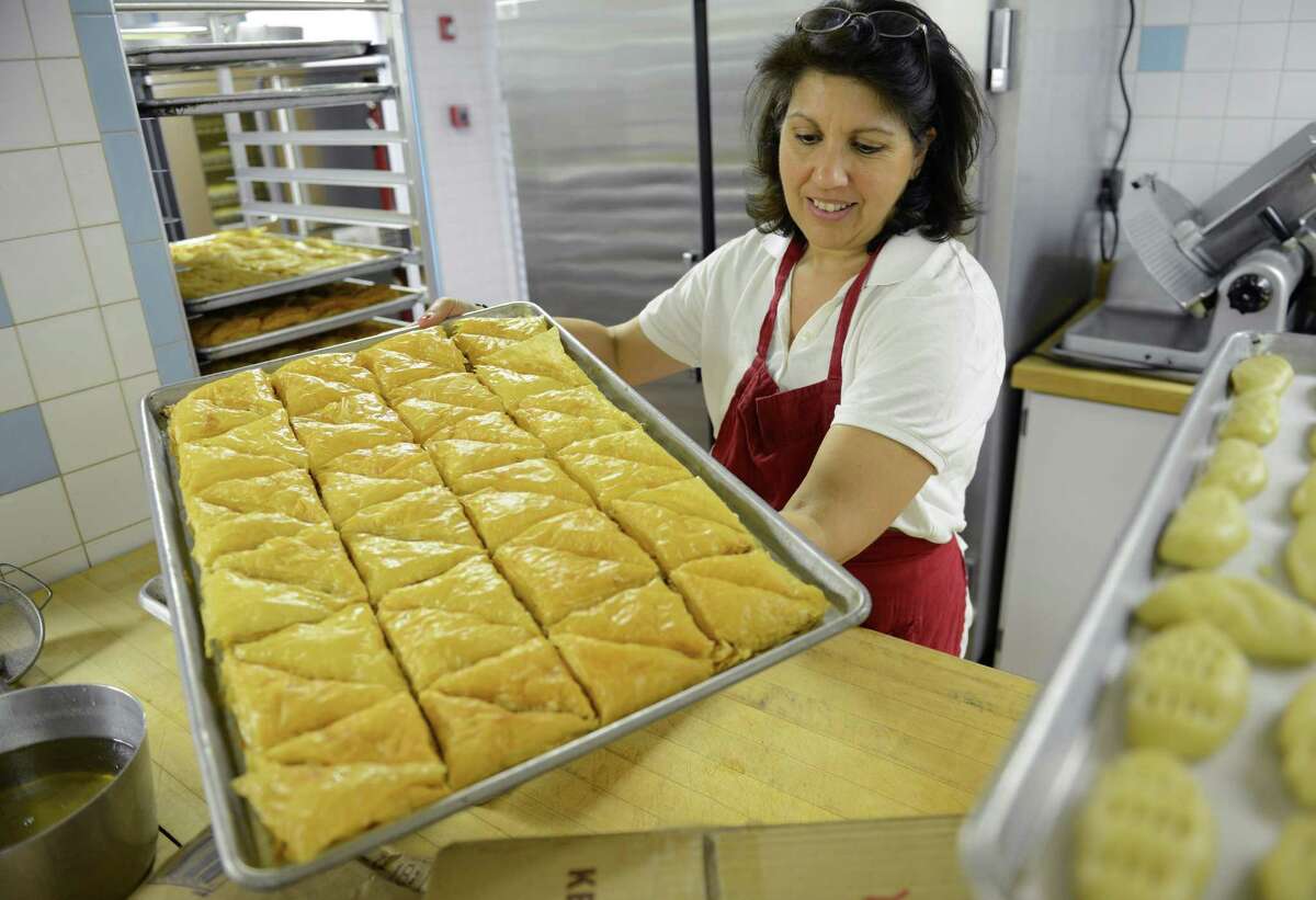 Tina Delasos, of Brookfield, handles a tray of fresh-baked baklava in preparation for the festival, The Greek Experience, at the Assumption Greek Orthodox Church in Danbury, Conn. on Tuesday, June 4, 2013. The festival runs Friday through Sunday and will have traditional Greek food, Greek dancing, raffles, games and other activities.