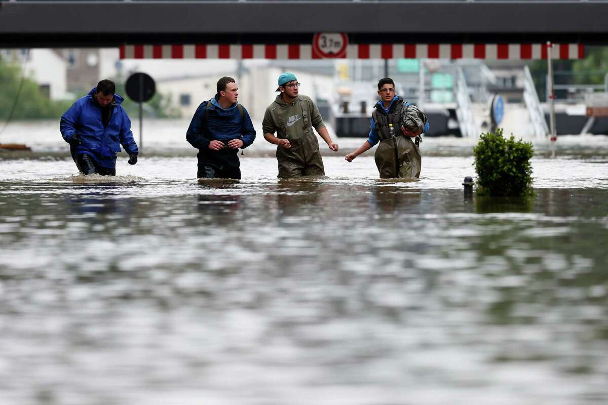 Volunteers walk through the flooded streets of the city Pirna, Germany, Tuesday, June 4, 2013. After heavy rainfalls swollen rivers flooded areas in Germany, Austria , Switzerland and Czech Republic. (AP Photo/Markus Schreiber)