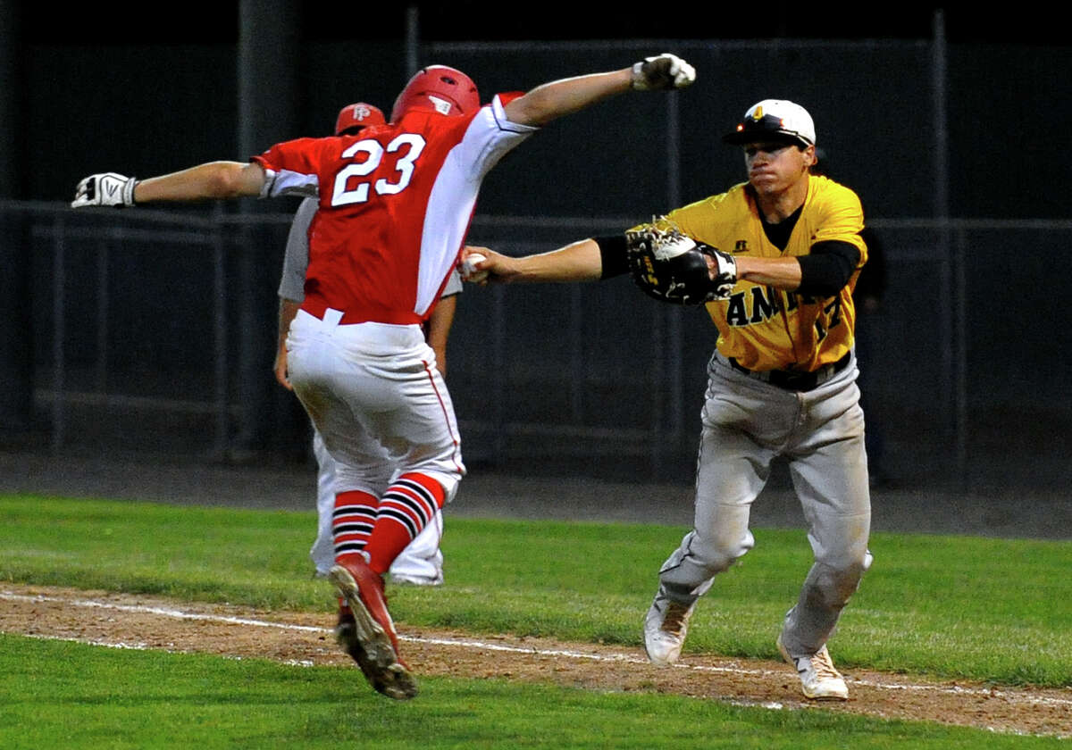 Fairfield Prep's Joe Ganim tries to avoid being tagged out on his way to first base by Amity's Justin Ashworth, during Class LL Semifinal baseball action in Bristol, Conn. on Tuesday June 5, 2013.
