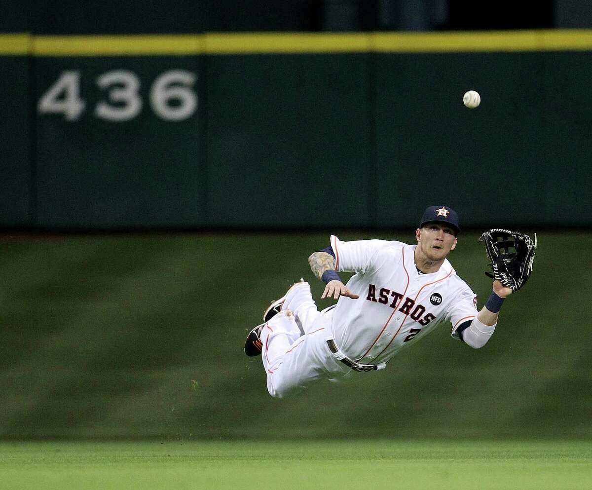 Astros center fielder Brandon Barnes has a bead on a line dive by Orioles third baseman Manny Machado in the fifth inning.