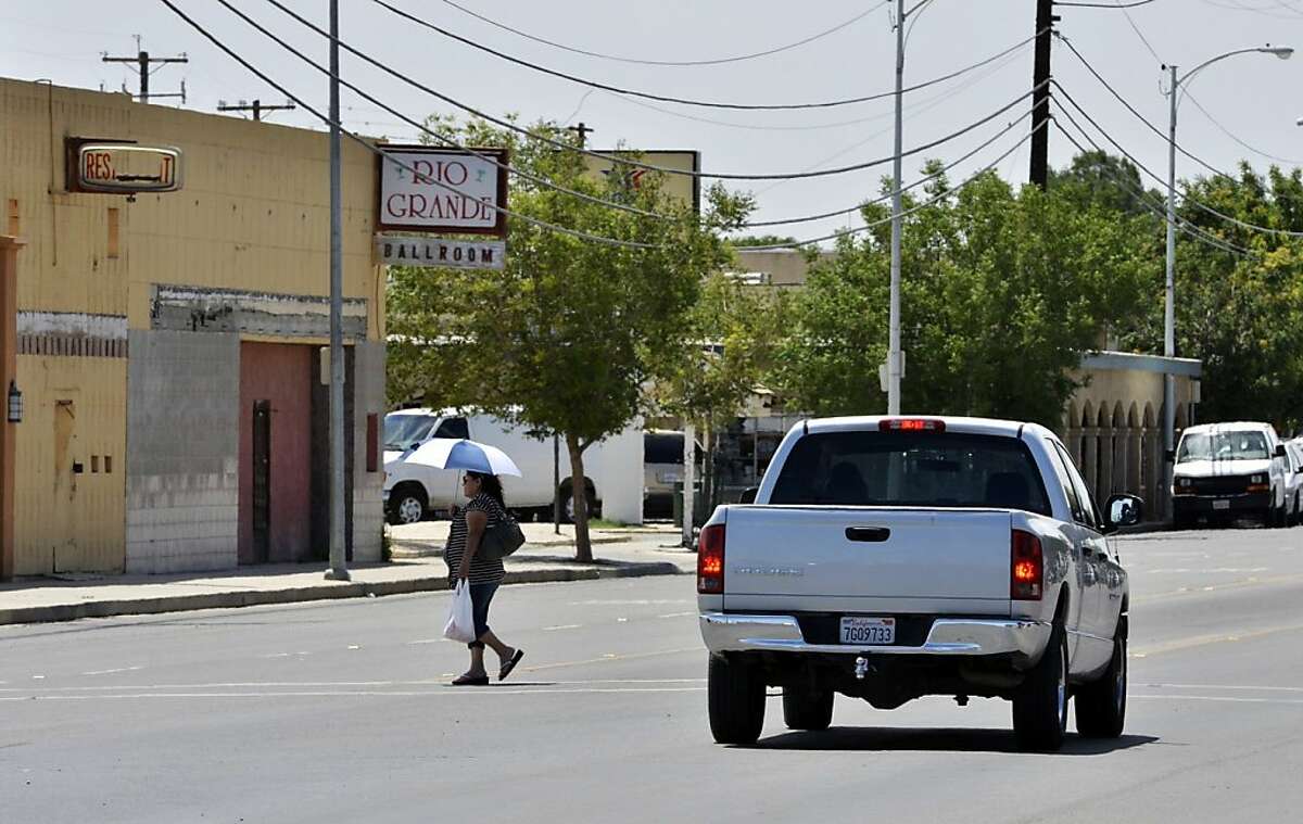 A woman crosses Lassen Avenue, May 21, 2013 in Huron, California. Huron is 98 percent Latino and the fourth-poorest place in California. (Eric Paul Zamora/Fresno Bee/MCT)