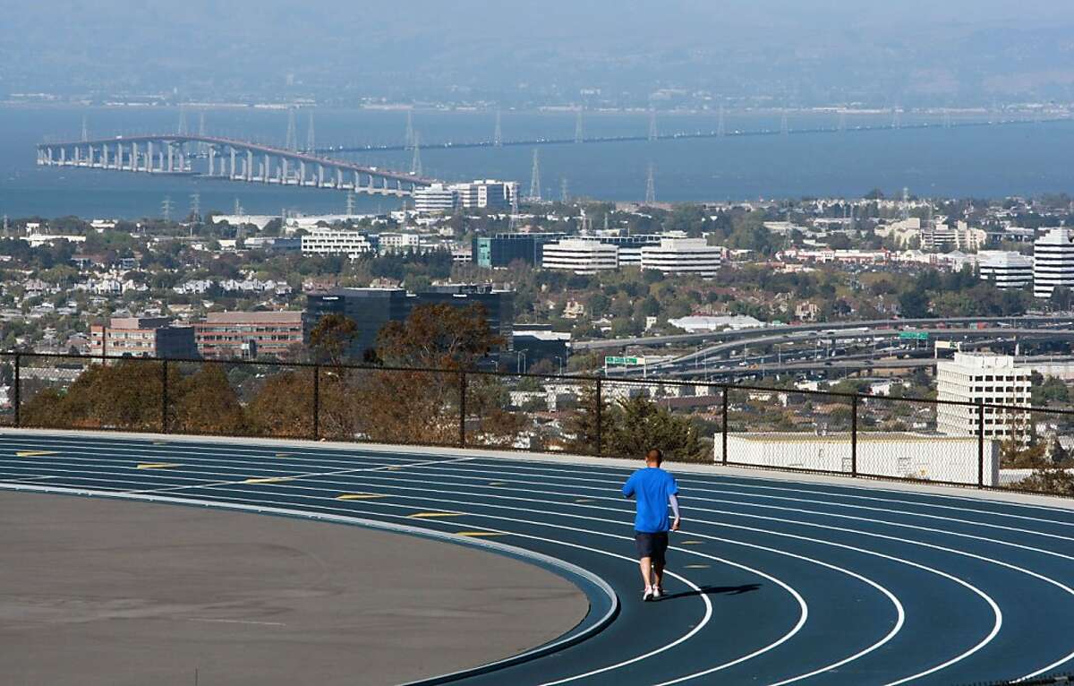 A jogger takes advantage of San Mateo City College track and its almost perfect weather and view of the city as he runs laps.