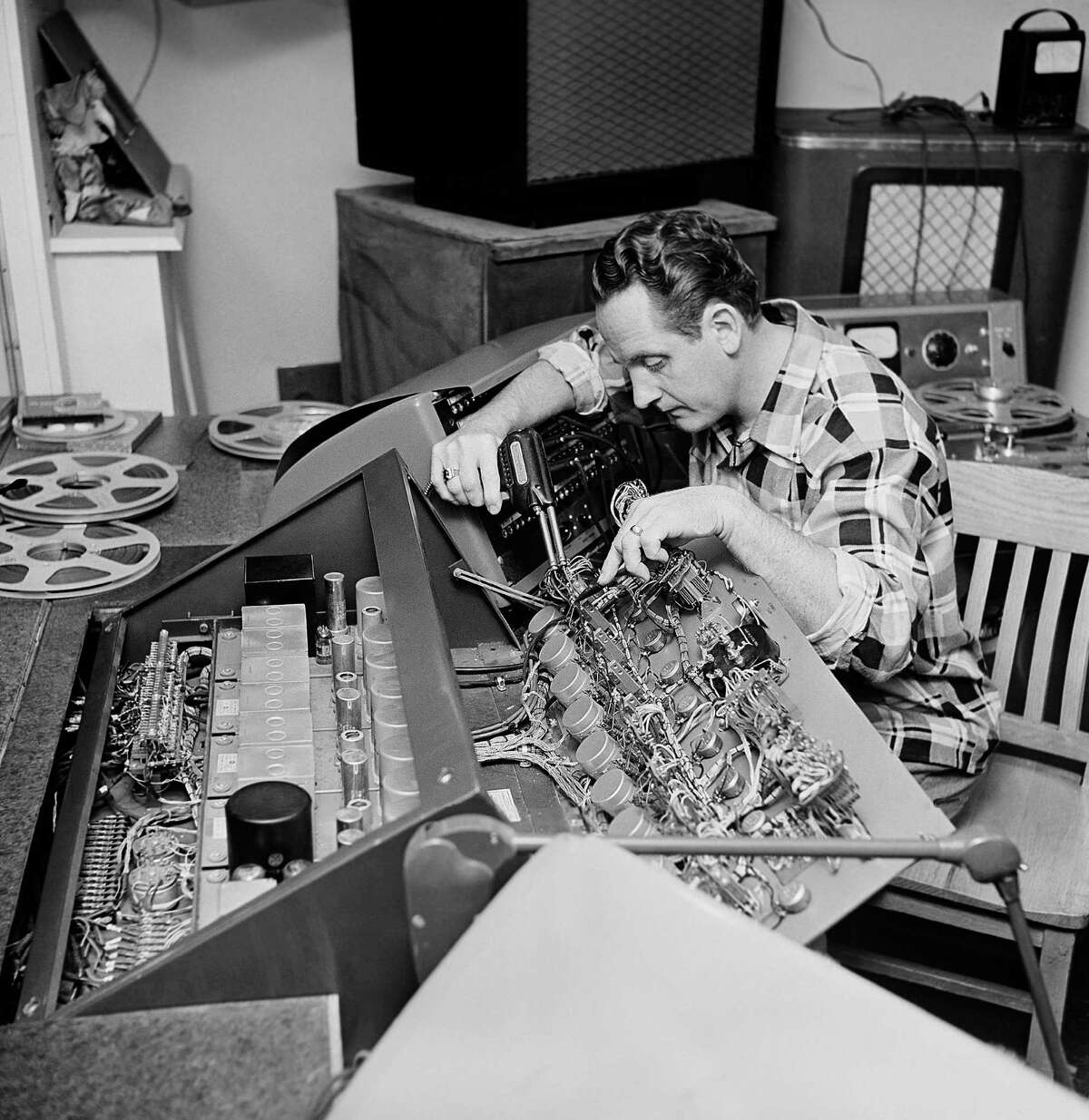 FILE - In this Dec. 20, 1963 file photo, Les Paul repairs one of the many control boards in the control room at his Oakland, N.J., home. Les Paul was a renown musician also known for his innovations on the solid body electric guitar and multitrack recording. The man who helped pave the way for rock 'n' roll is finally getting a permanent exhibit on June 9, 2013 at the Waukesha County Museum in his Wisconsin hometown. (AP Photo/Dan Grossi, file)